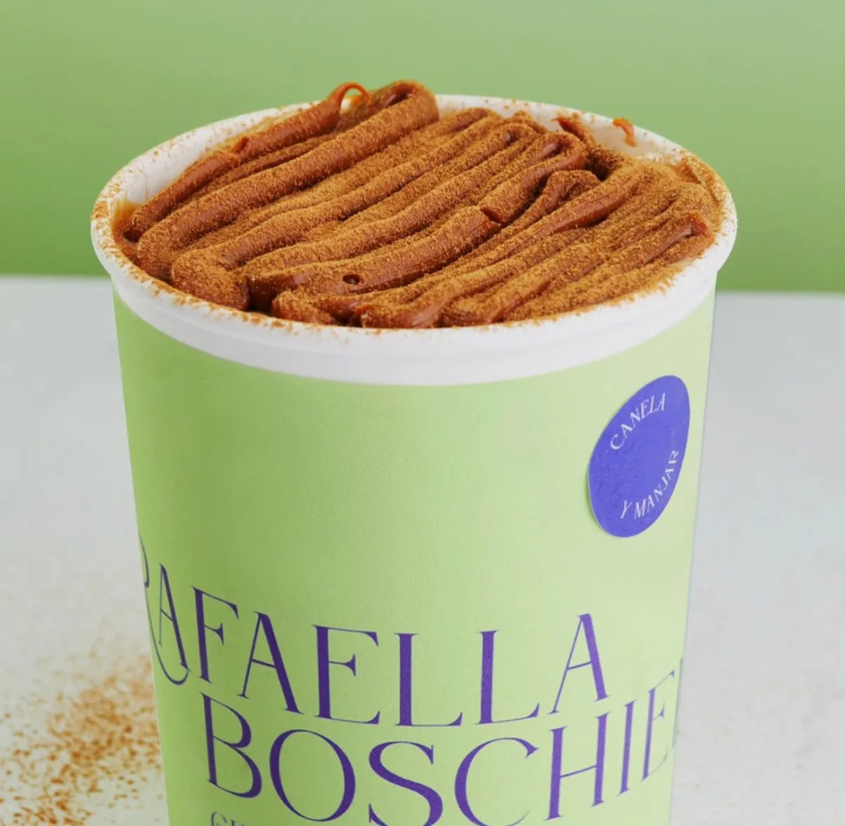 Pote de gelato de canela con gruesas cintas de manjarblanco por encima