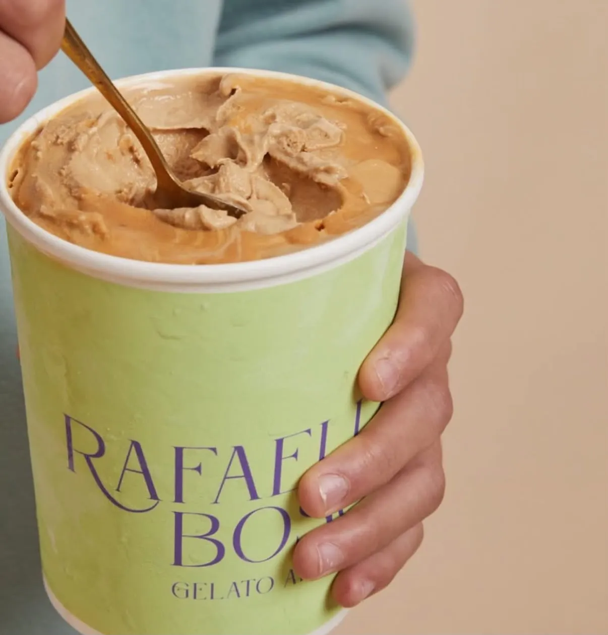 Pote de gelato de dulce de leche siendo removido con una cuchara