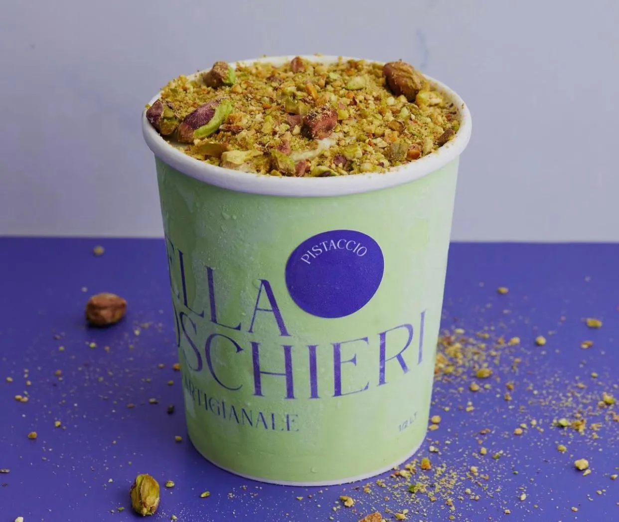 Pote de gelato de pistacho cubierto con pistacho molido y en trozos